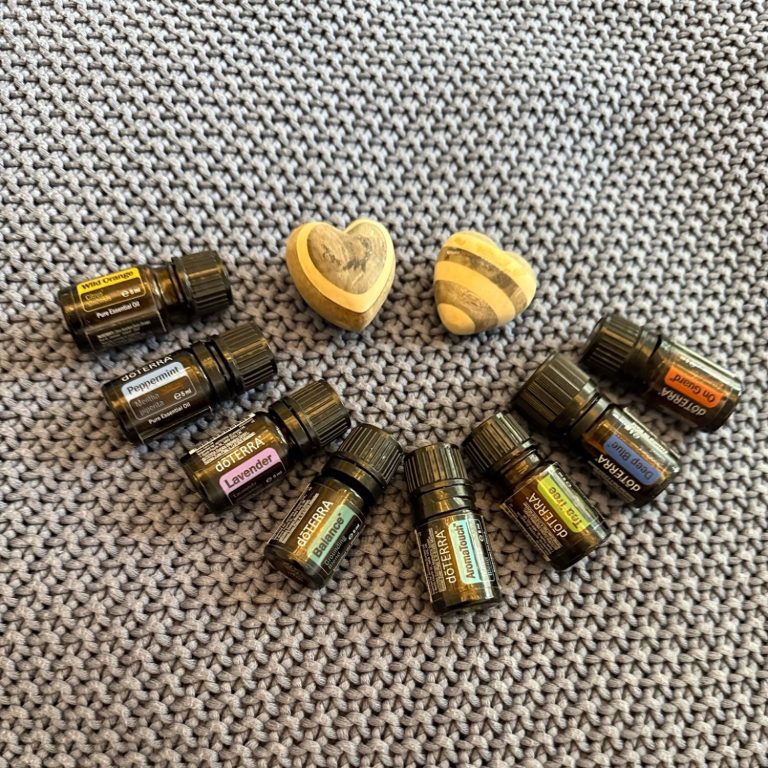 Zwei Herzen und mehrere Flaschen ätherischer Öle als Smiley auf einem karierten Hintergrund.